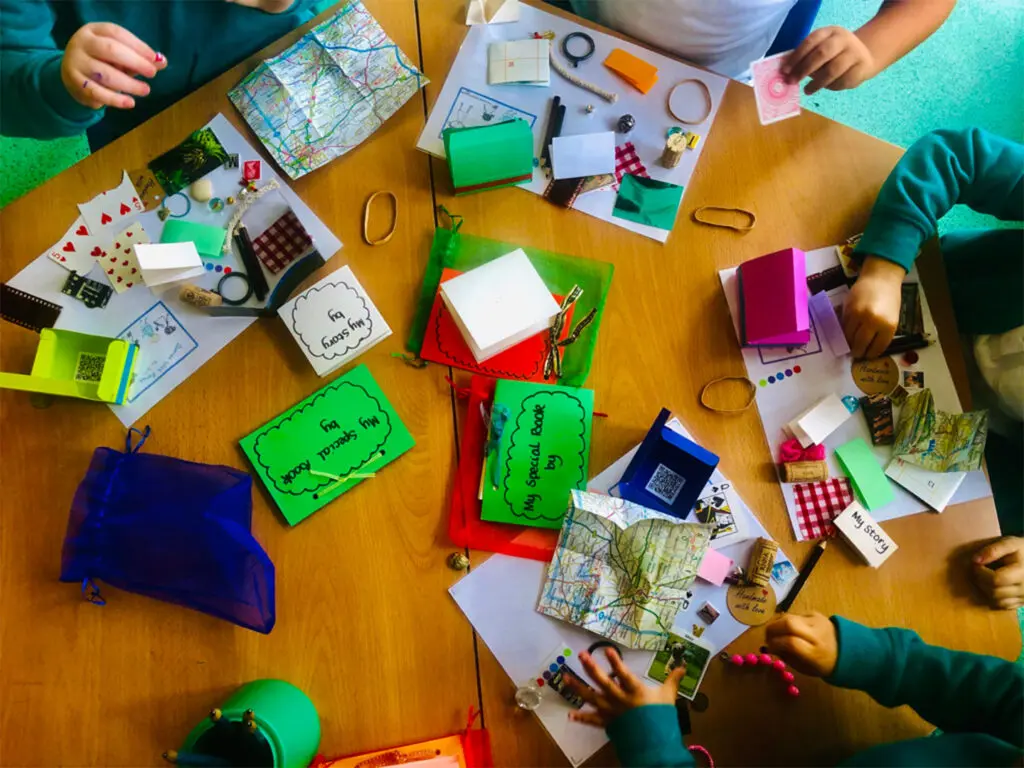 A group of people sitting around a table with many items.