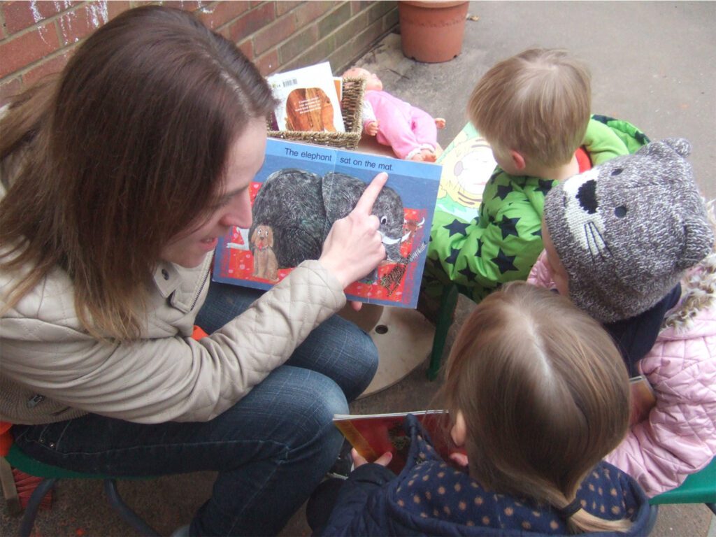 A woman sitting on the ground with two children.