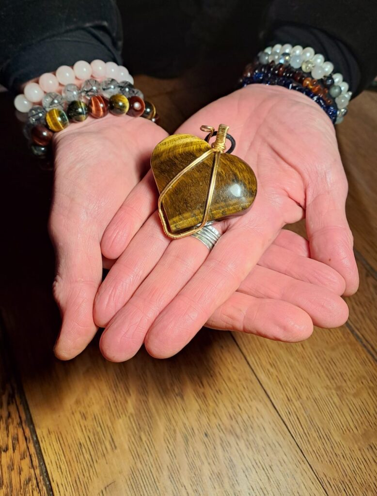 A person holding their hands with a stone in them.