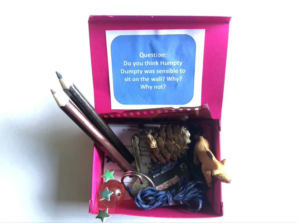 A pink box with some pencils and other items