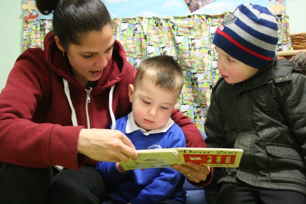A woman reading to two children