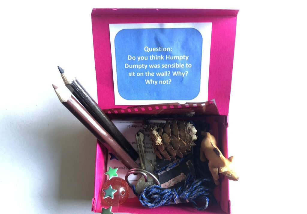 A pink box with some pencils and other items