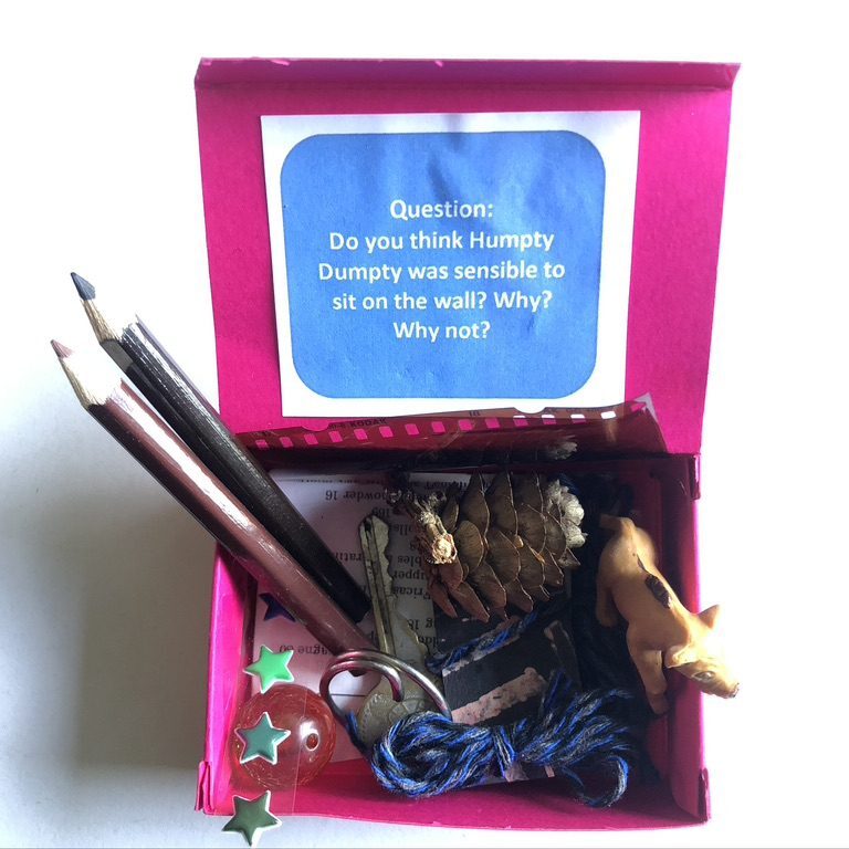 A pink box with some pencils and other items