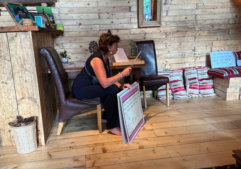 A woman sitting on top of a chair reading.