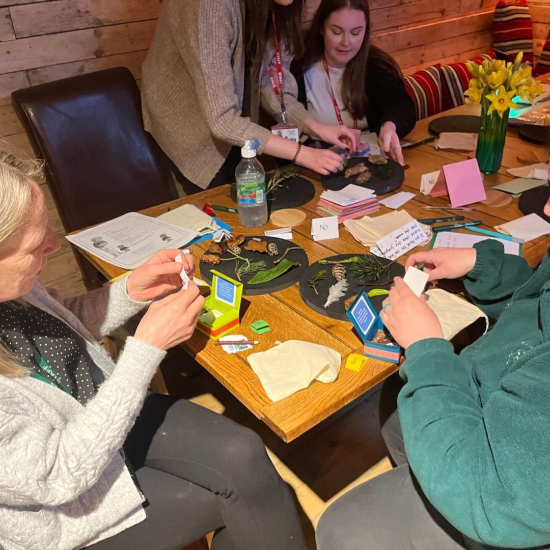 A group of people sitting around a table playing cards.